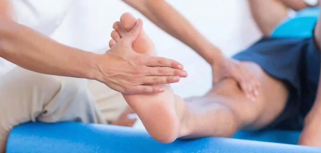 osteópata tratando pie paciente en clínica de fisioterapia